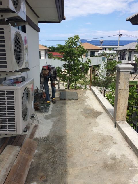 Laying tile on the upstairs wrap around balcony.